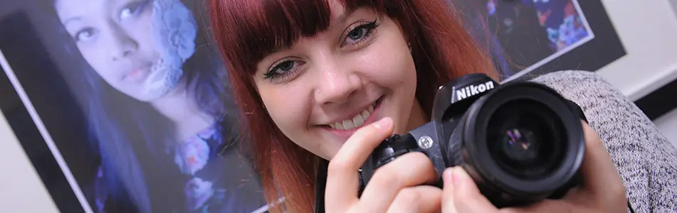 girl with a camera smiling